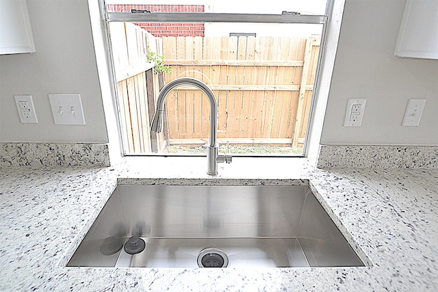 room details featuring sink and light stone counters