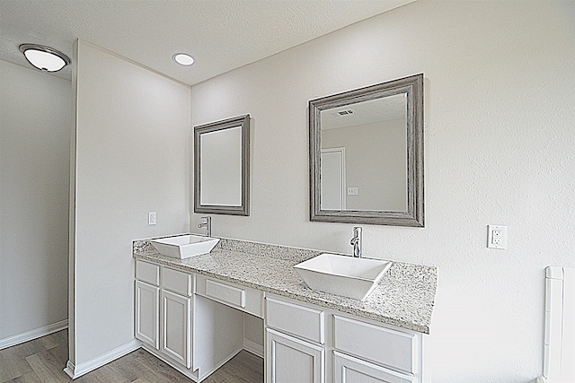 bathroom with vanity, a textured ceiling, and wood-type flooring