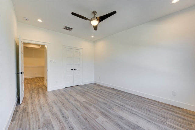 unfurnished bedroom featuring light wood-type flooring, a closet, and ceiling fan