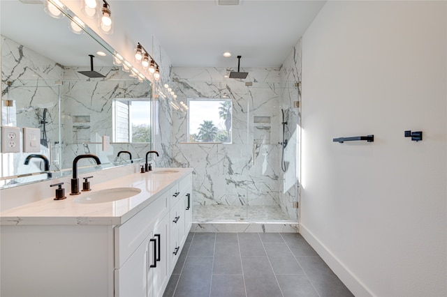 bathroom featuring tile patterned flooring, vanity, and a tile shower