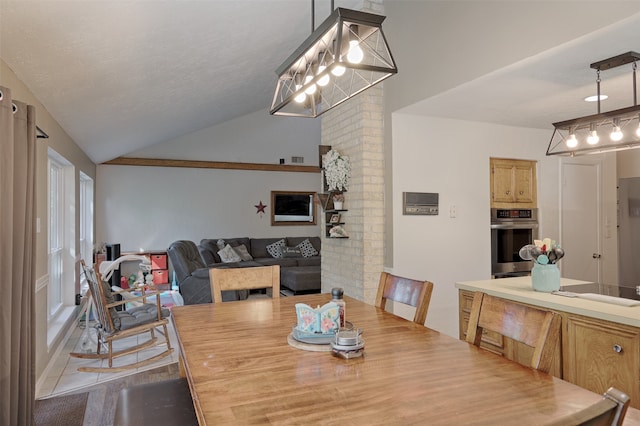 tiled dining space with a textured ceiling, an inviting chandelier, and lofted ceiling