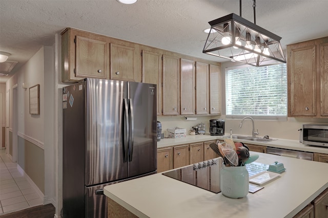 kitchen with sink, hanging light fixtures, a textured ceiling, and appliances with stainless steel finishes