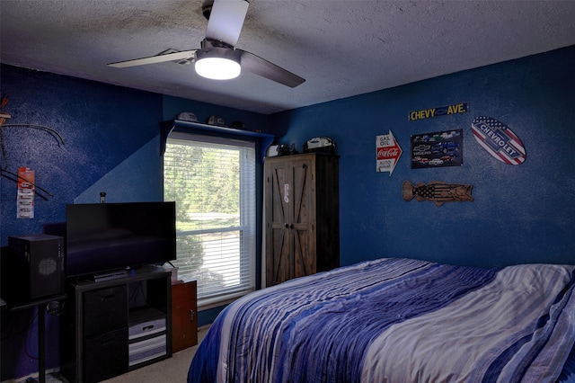 carpeted bedroom featuring ceiling fan and a textured ceiling