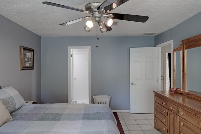 tiled bedroom featuring a textured ceiling and ceiling fan