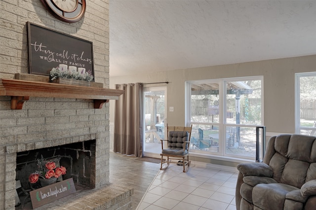 living room featuring a textured ceiling, light hardwood / wood-style flooring, and a brick fireplace