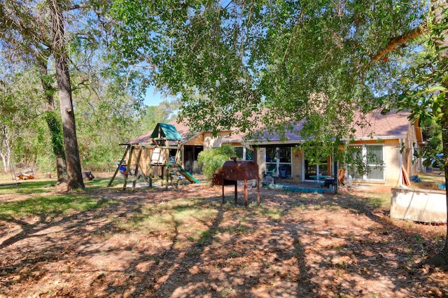 back of property with a playground