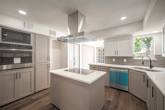 kitchen featuring black appliances, sink, a kitchen island, island exhaust hood, and dark hardwood / wood-style floors