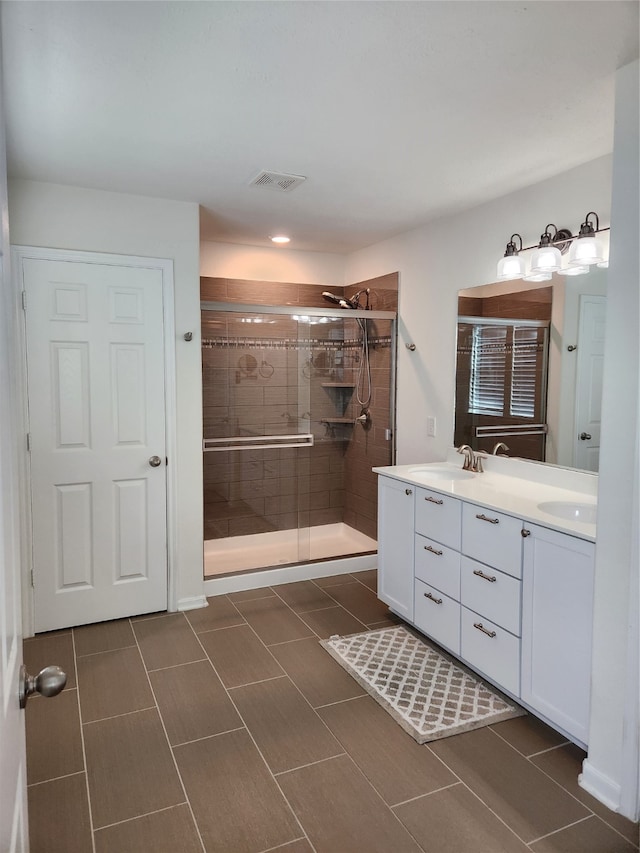 bathroom with vanity and a shower with door