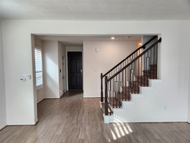 foyer entrance with a textured ceiling and hardwood / wood-style flooring