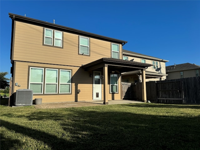 rear view of property with a yard and central AC unit