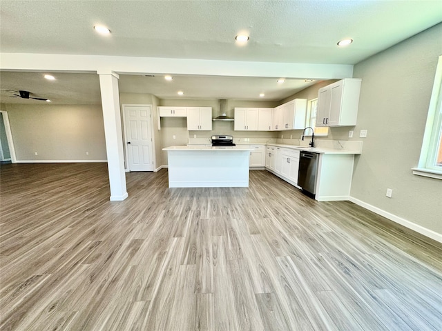 kitchen with light hardwood / wood-style floors, wall chimney exhaust hood, white cabinetry, and stainless steel appliances