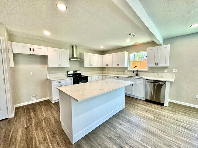 kitchen with wall chimney exhaust hood, white cabinets, stainless steel appliances, and light wood-type flooring