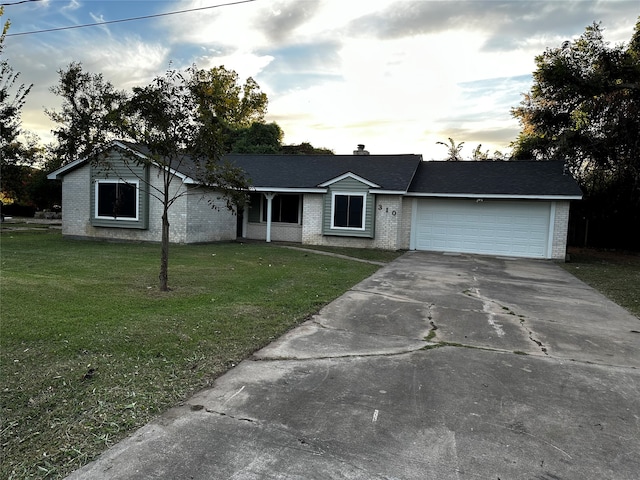 ranch-style house featuring a garage and a lawn