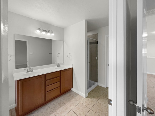 bathroom featuring vanity, a textured ceiling, a shower with shower door, and tile patterned flooring