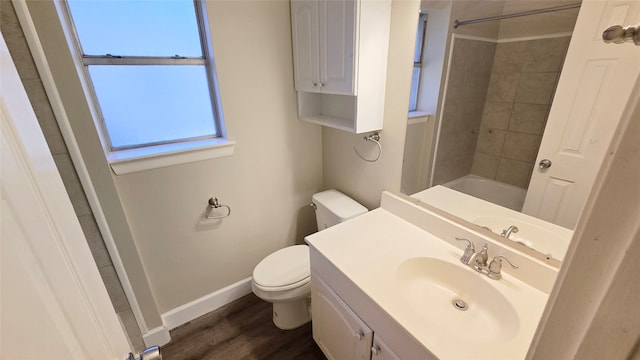 full bathroom featuring vanity, tiled shower / bath combo, hardwood / wood-style flooring, and toilet