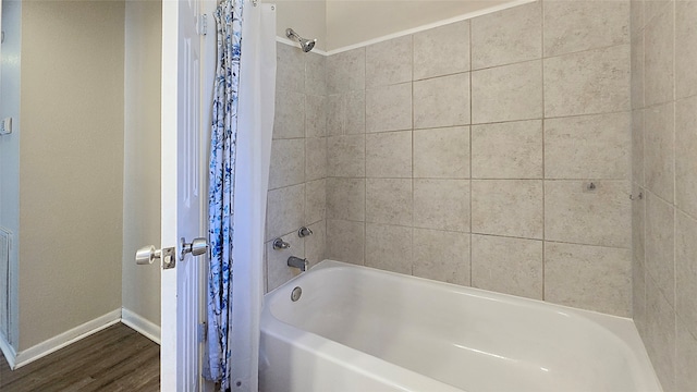 bathroom with wood-type flooring and shower / bath combo with shower curtain