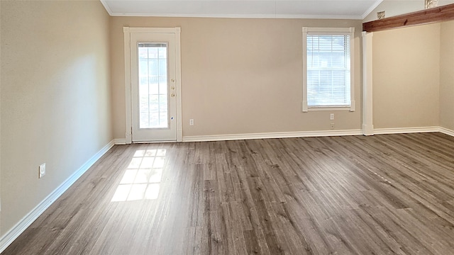 spare room featuring crown molding and dark hardwood / wood-style flooring