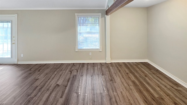 unfurnished room with dark wood-type flooring, crown molding, and plenty of natural light