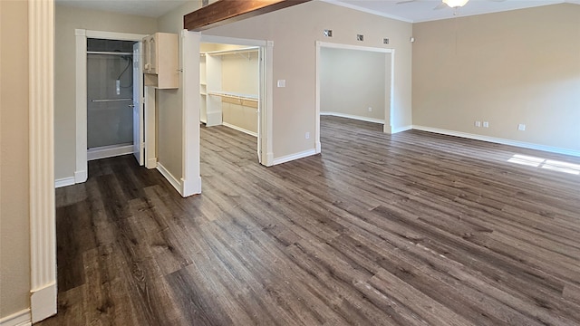 empty room with ornamental molding, dark wood-type flooring, and ceiling fan