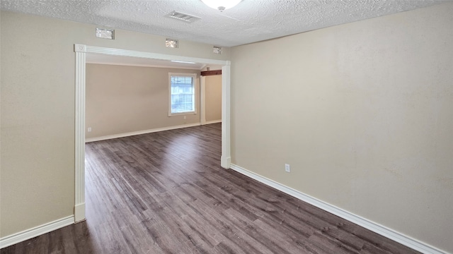 unfurnished room featuring a textured ceiling and dark wood-type flooring