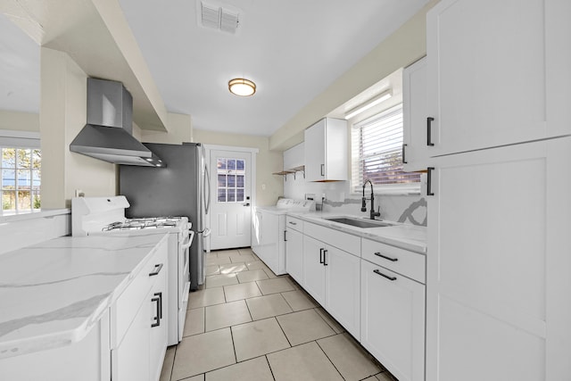 kitchen with wall chimney range hood, sink, plenty of natural light, and white range