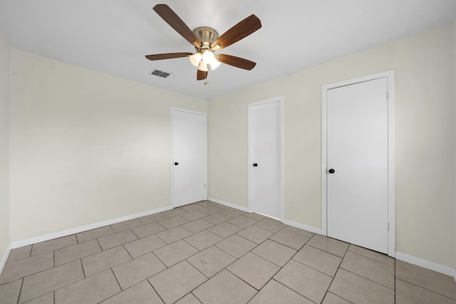 unfurnished bedroom with light tile patterned floors and ceiling fan