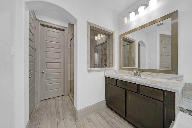 bathroom featuring vanity, walk in shower, and hardwood / wood-style floors