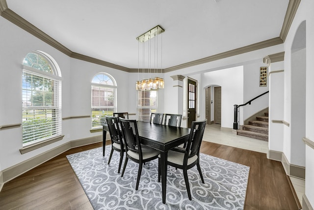 dining area featuring ornamental molding, hardwood / wood-style floors, and a notable chandelier