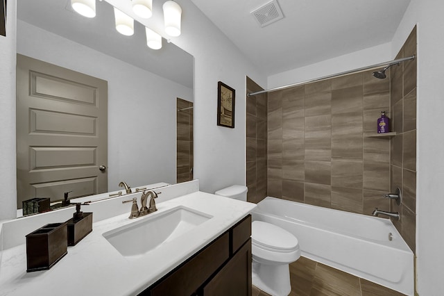 full bathroom with toilet, tiled shower / bath combo, vanity, and hardwood / wood-style floors