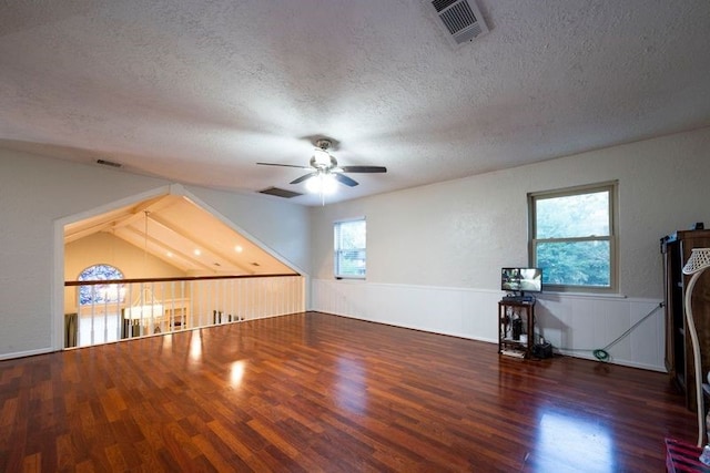 unfurnished living room featuring a textured ceiling, ceiling fan, and dark wood-type flooring