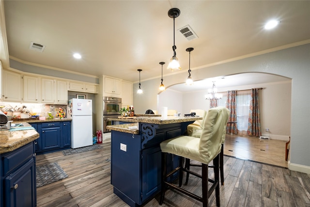 kitchen with dark hardwood / wood-style flooring, blue cabinetry, white refrigerator, white cabinets, and a center island