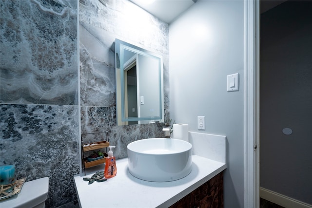 bathroom featuring vanity, tasteful backsplash, and toilet