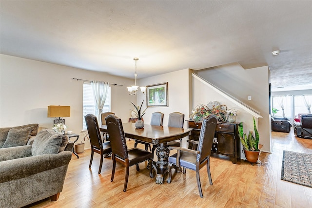 dining space featuring an inviting chandelier, plenty of natural light, and light hardwood / wood-style flooring