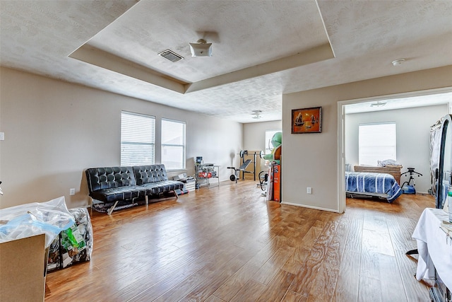 interior space with a tray ceiling and light hardwood / wood-style flooring