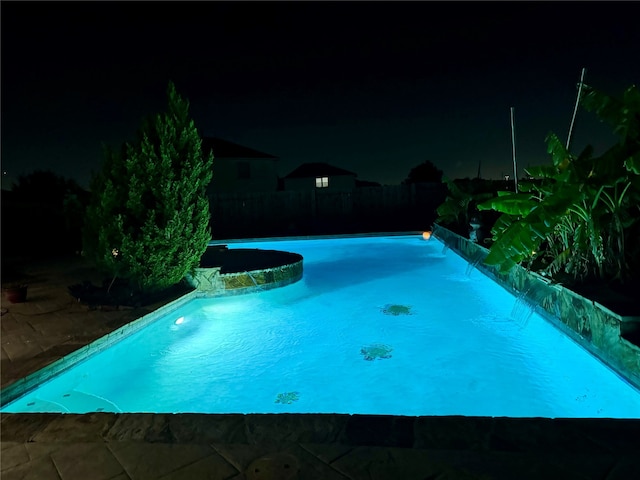 view of pool at twilight