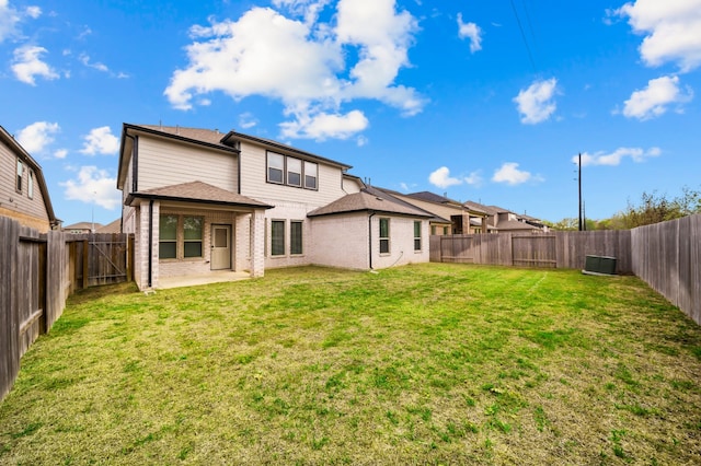 rear view of property featuring a patio area, central AC, and a lawn