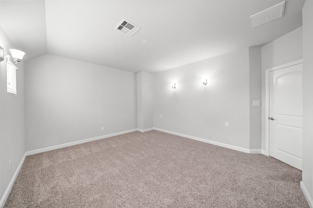 carpeted spare room featuring lofted ceiling