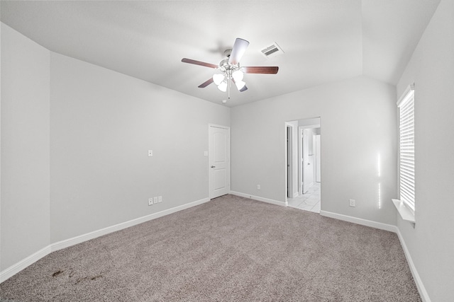 empty room with lofted ceiling, light colored carpet, and ceiling fan