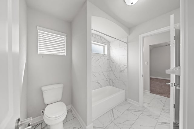 bathroom with toilet and tiled shower / bath combo