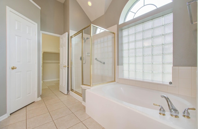 bathroom with tile patterned floors, a garden tub, a shower stall, and a walk in closet