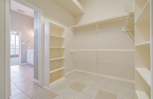 walk in closet with light tile patterned floors