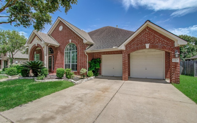 view of front of house featuring concrete driveway, brick siding, a front yard, and a garage