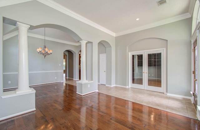 spare room featuring baseboards, crown molding, wood finished floors, and visible vents