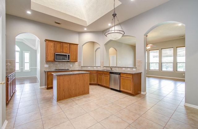 kitchen with recessed lighting, plenty of natural light, a center island, tasteful backsplash, and appliances with stainless steel finishes