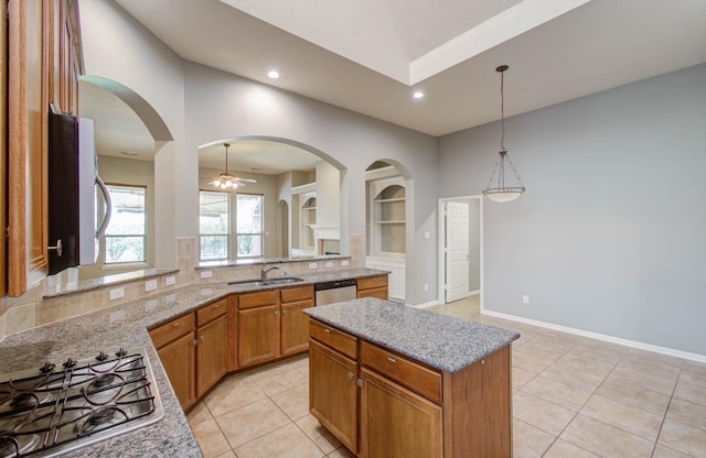 kitchen with a ceiling fan, light tile patterned floors, a sink, light stone countertops, and appliances with stainless steel finishes