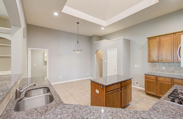 kitchen with arched walkways, light tile patterned flooring, a sink, and hanging light fixtures