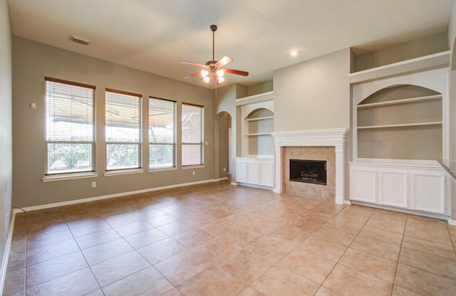 unfurnished living room with visible vents, baseboards, built in features, a ceiling fan, and light tile patterned floors