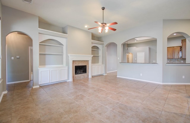 unfurnished living room featuring light tile patterned flooring, ceiling fan, built in features, baseboards, and recessed lighting