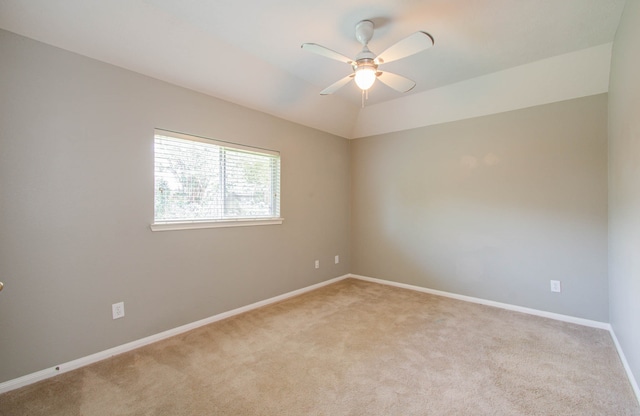 unfurnished room featuring ceiling fan, vaulted ceiling, and light colored carpet