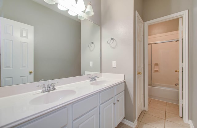 full bathroom with double vanity, tile patterned flooring, baseboards, and a sink